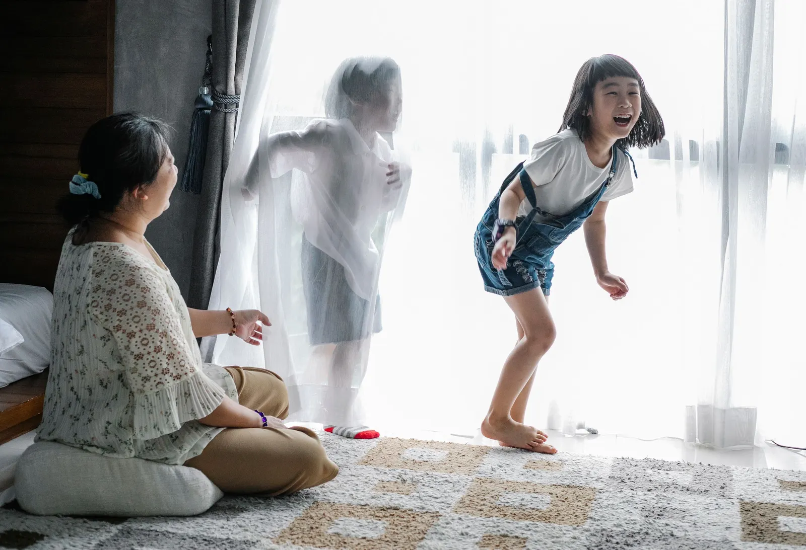 Babysitter playing with two young girls at home